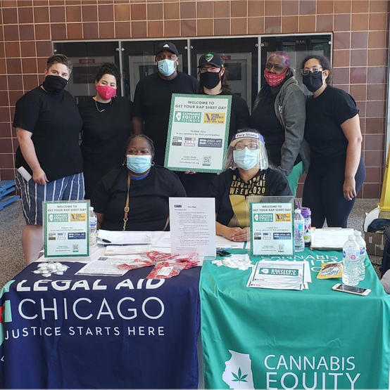An image of Legal Aid Chicago and Cannabis Equity Illinois Coalition at a resource fair. The members are standing in front of tables with their logos on them.
