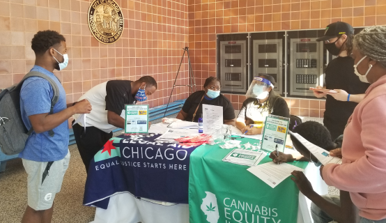Coalition members hosting a record clearing event with Cannabis Equity Illinois Coalition signage.